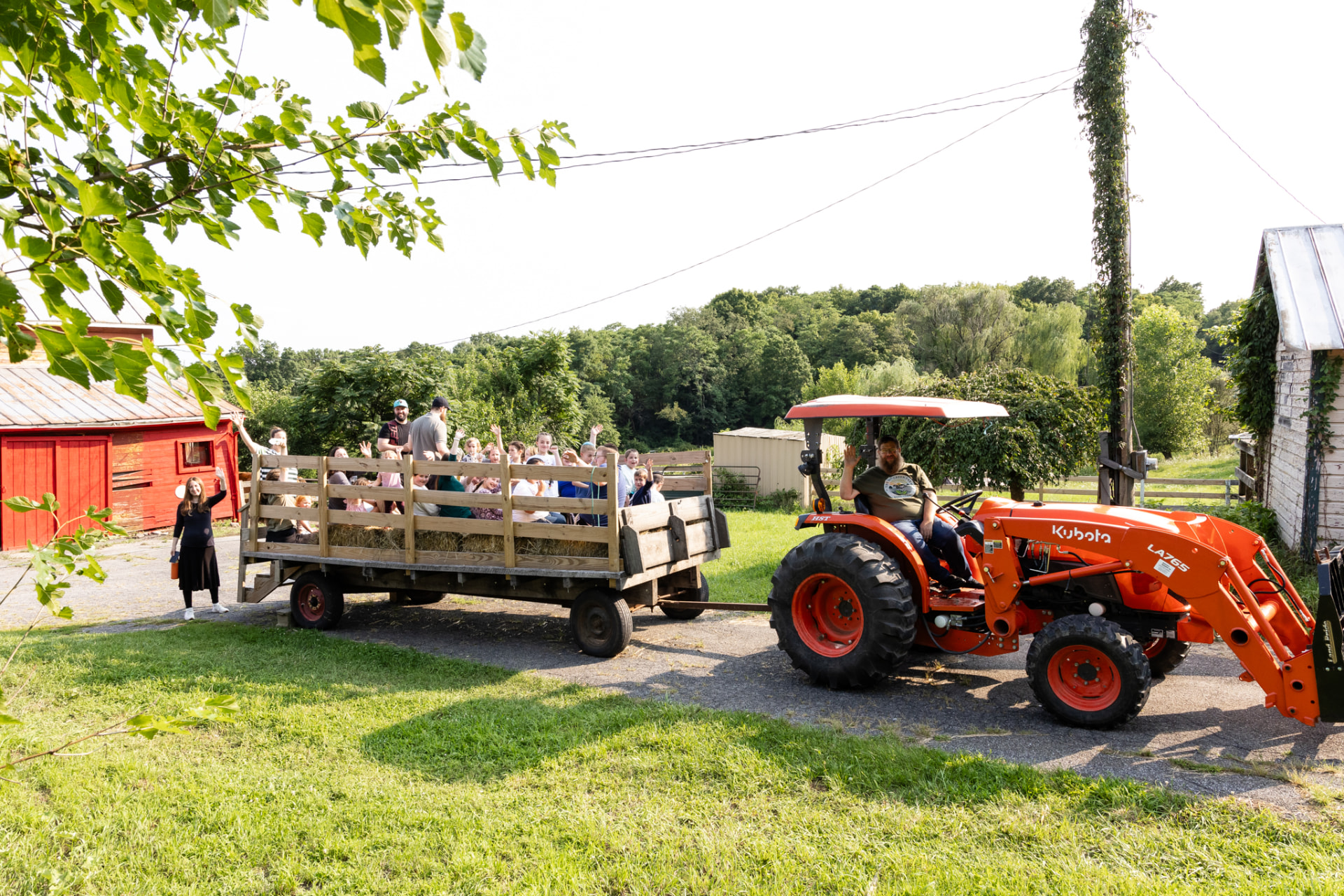 Orange tractor pulling a wagon full of children on a hayride